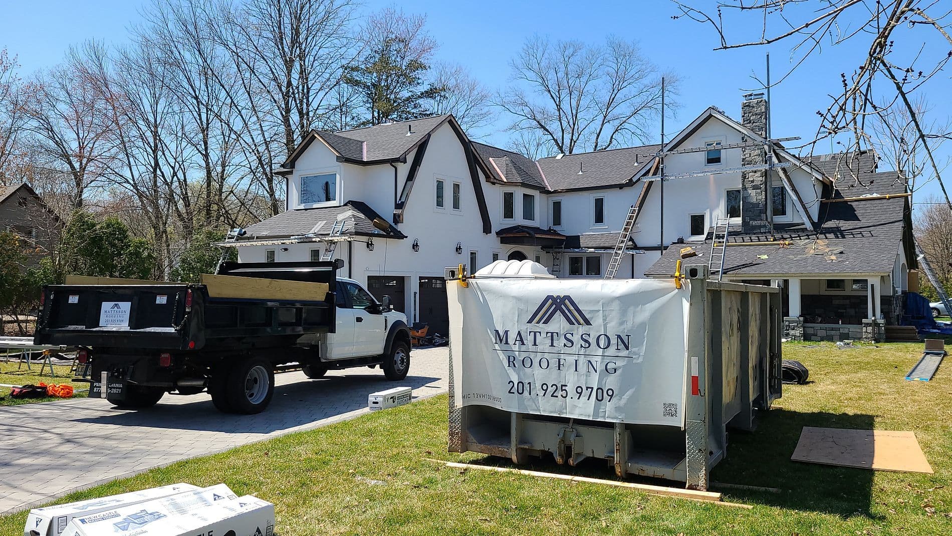 ames in progress front of dumpster with dump truck