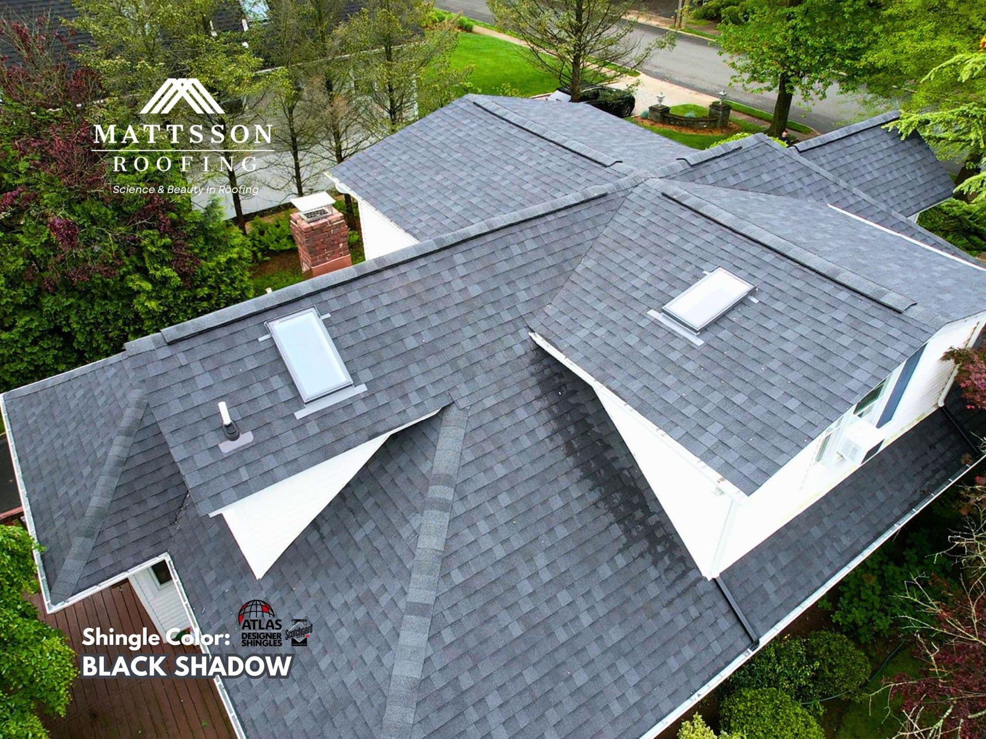 Completed residential roof replacement in Glen Rock featuring Atlas Roofing Pinnacle Pristine Black Shadow shingles, new VELUX skylights, copper chimney flashing, and ridge vent ventilation.